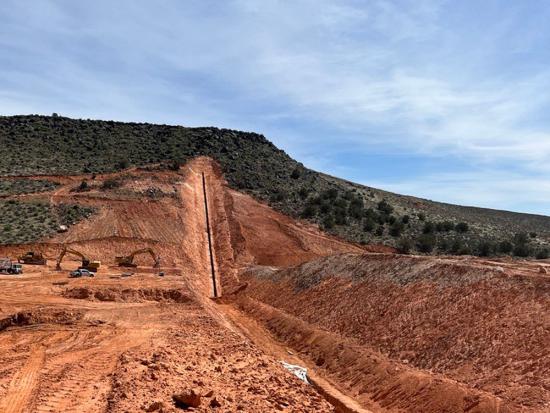 Construction area of a pipeline area through red dirt. 