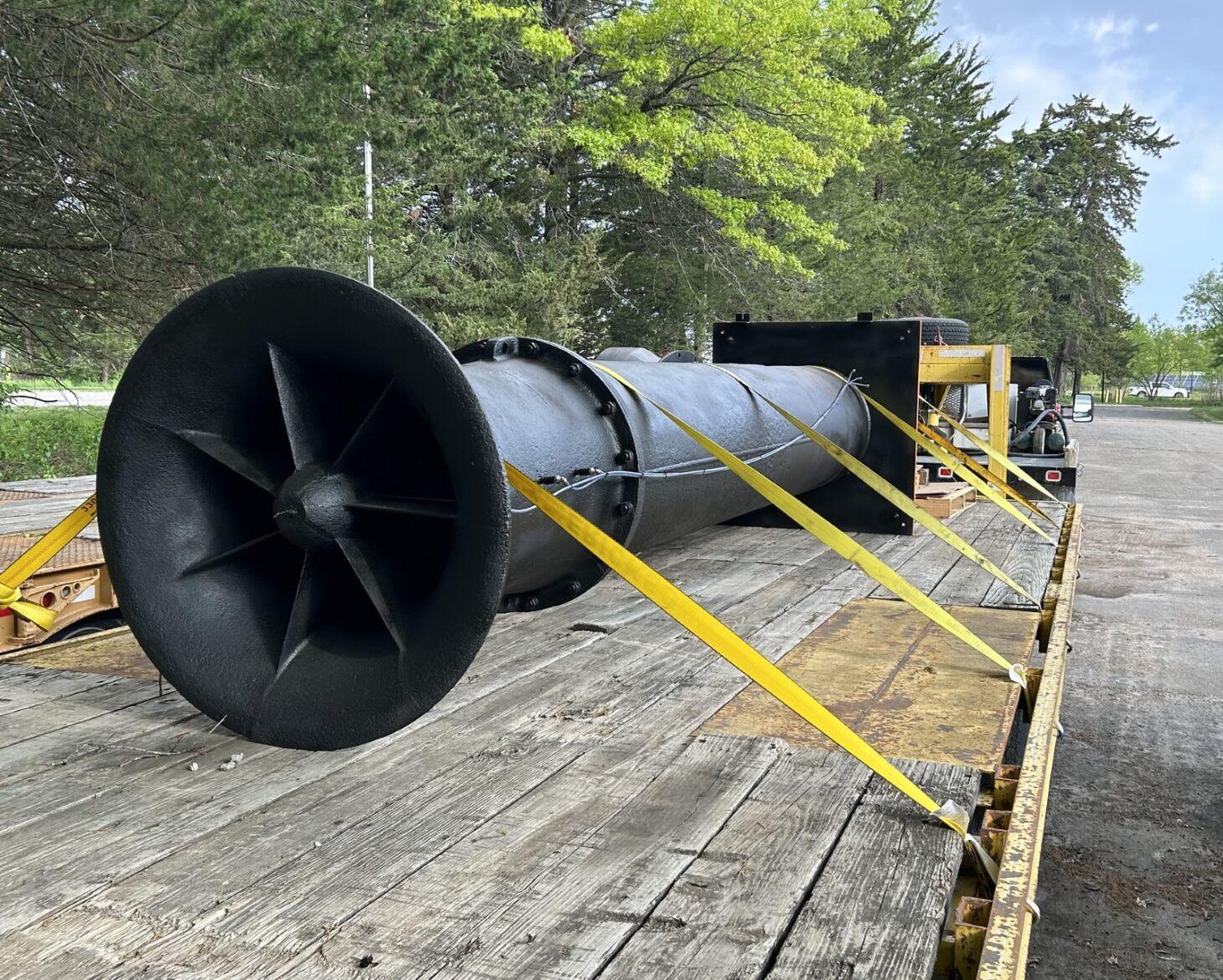 Large black pump strapped onto a truck bed.