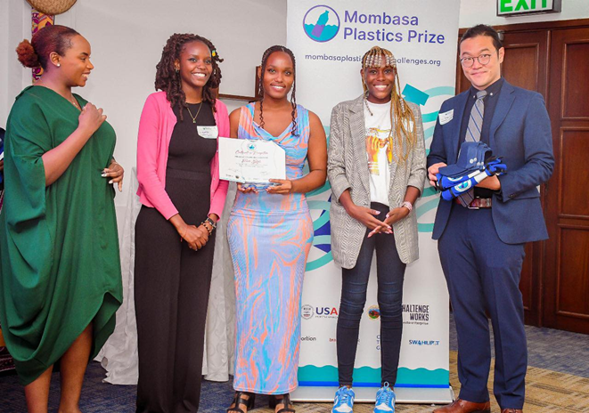 Mombasa Plastics Prize Winners pose in front of banner