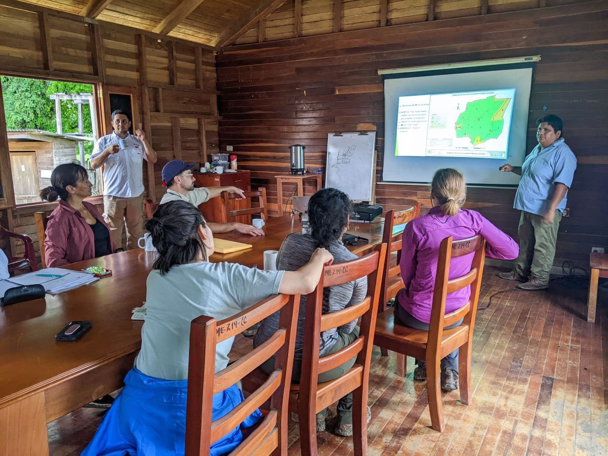 A group sits at a table in Guatemala working