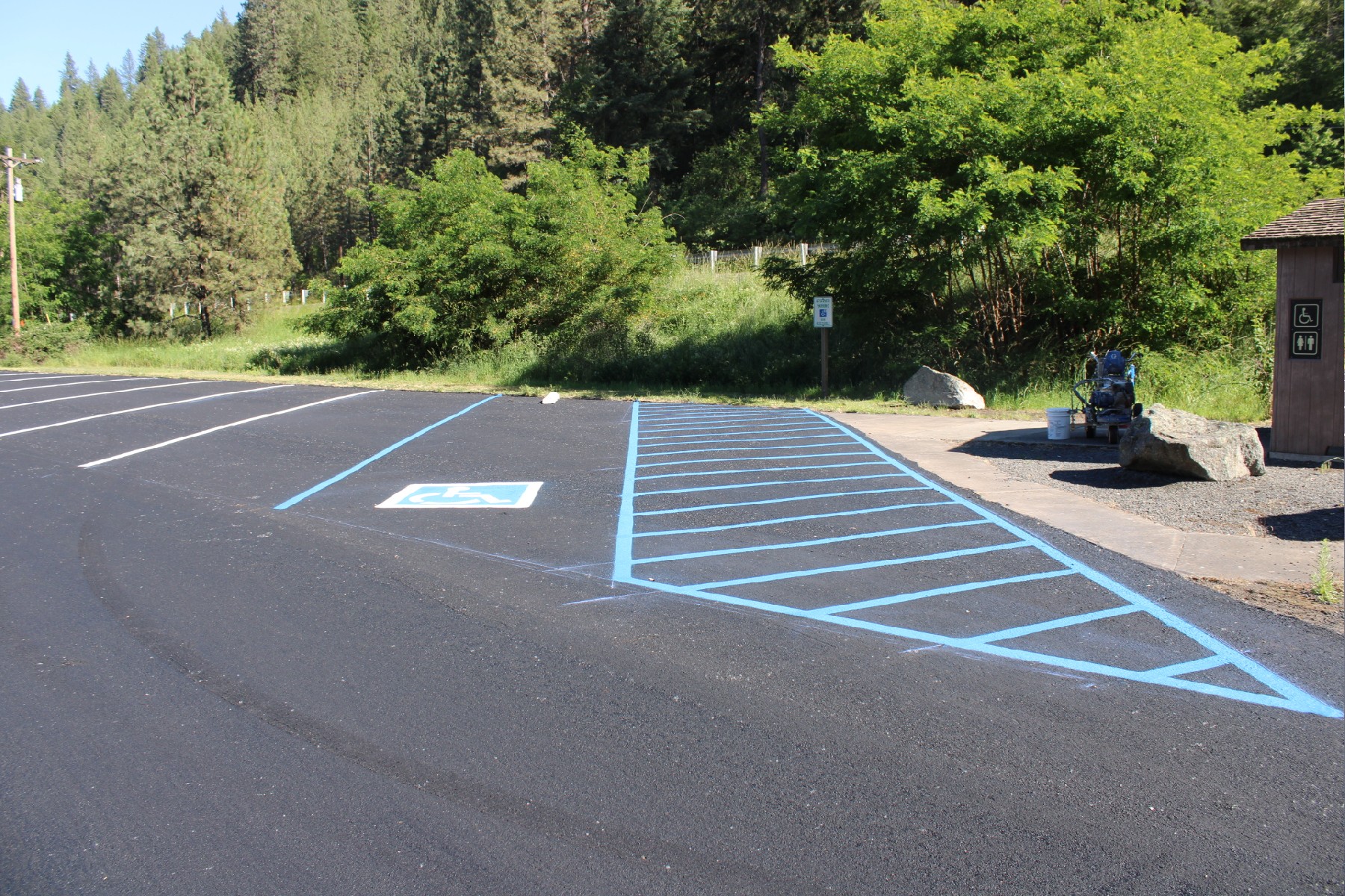 Parking lot with smooth asphalt and bright blue handicap parking lines.