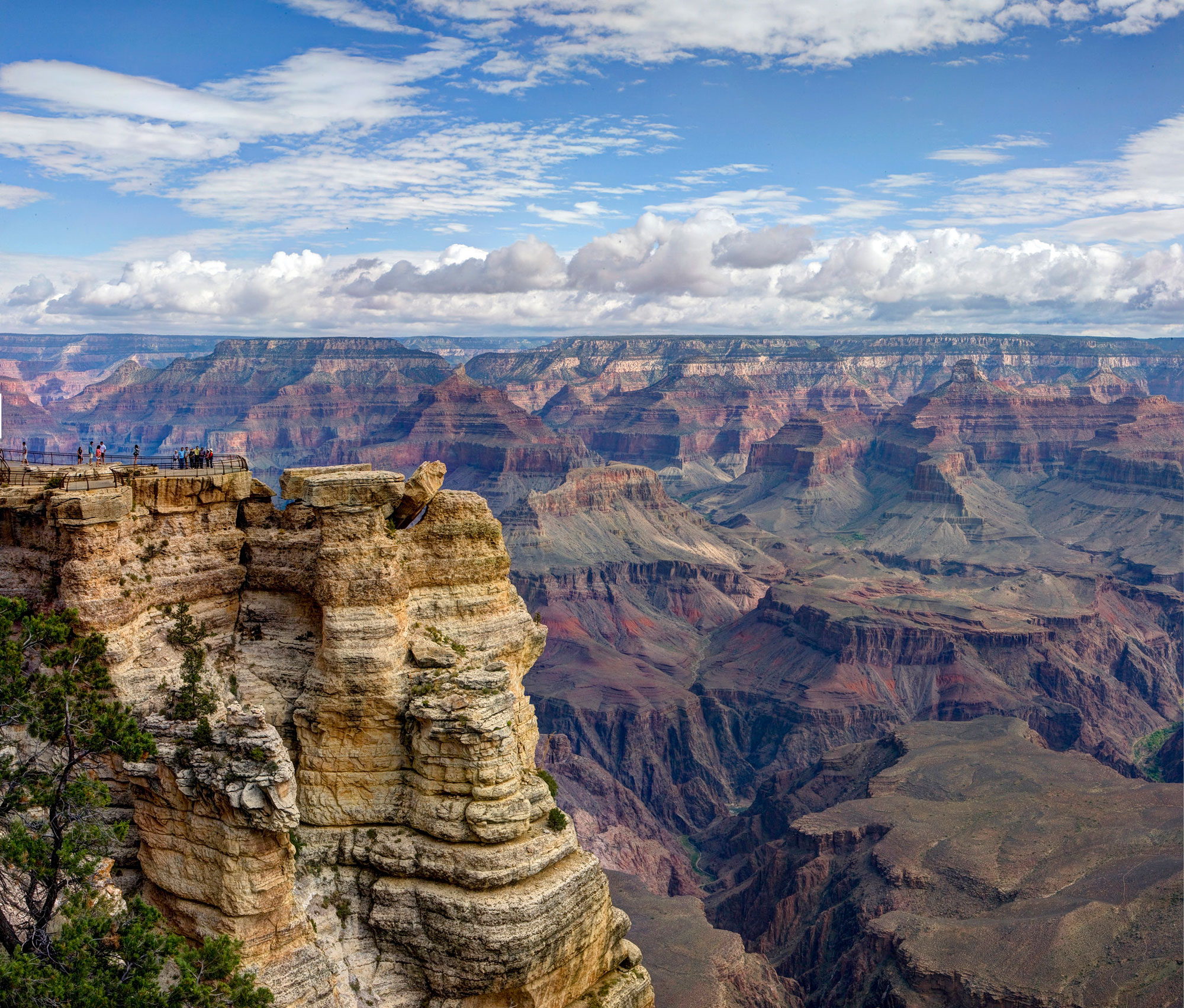 Layered rocky canyon with a blue cloudy sky. 