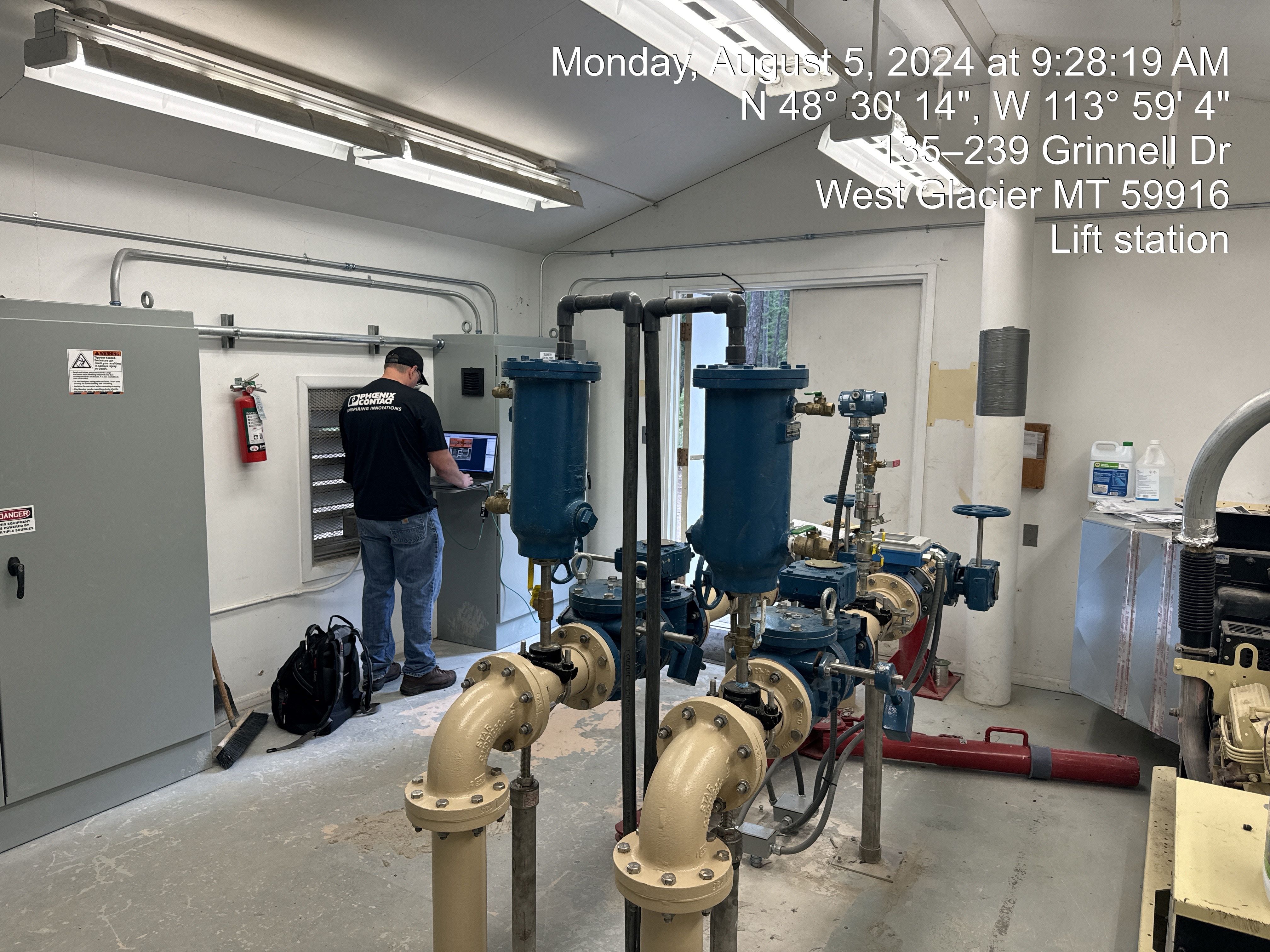 Wastewater system inside white room with concrete floor.