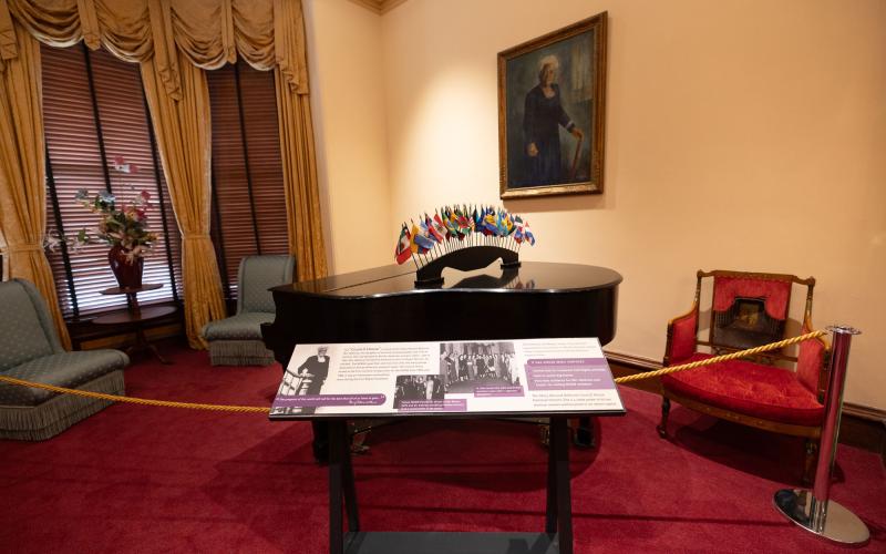 An exhibit panel in front of a grand piano