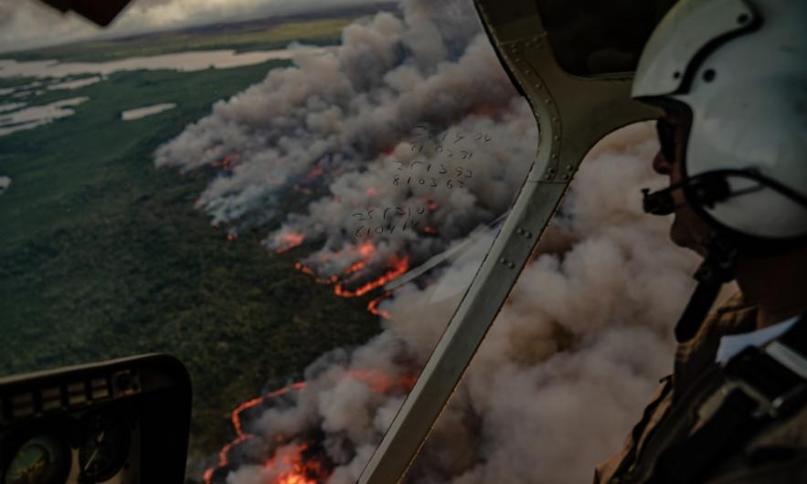 Helicopter pilot overlooks wildfire.