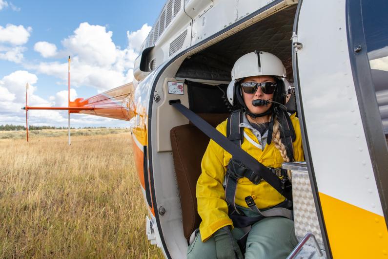 Helitack crew member ready for flight with a plastic sphere dispenser.