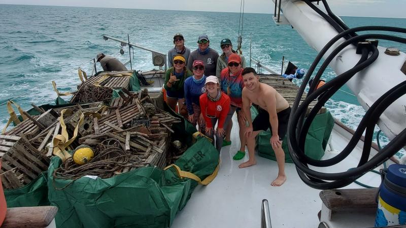 Debris removal divers on deck with cache of debris