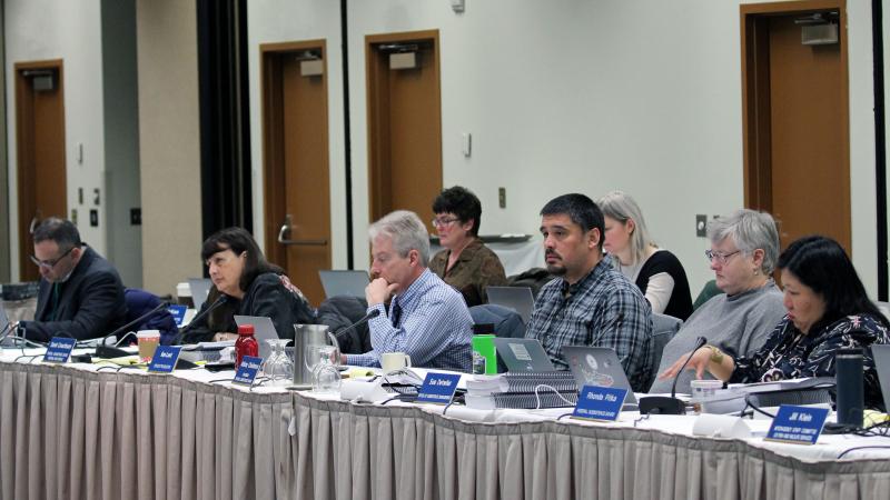 Men and women sitting at a table listening