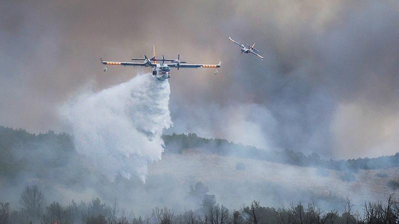 A water bomber drops water on a fire. Photo by Mike McMillan, BLM.