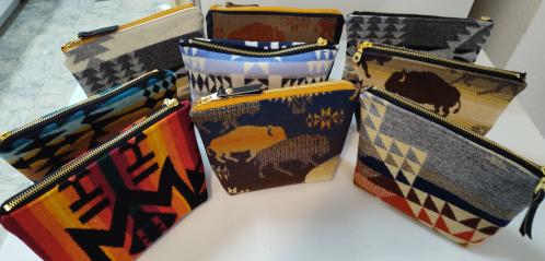 Photograph of multiple bags and pouches made from Pendleton wool fabric.