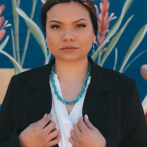 Photograph of a woman wearing a turquoise necklace.