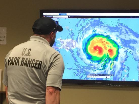 A man watches a hurricane's path on-screen