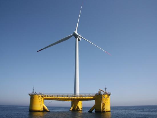 Wind turbine on floating yellow base in the ocean.