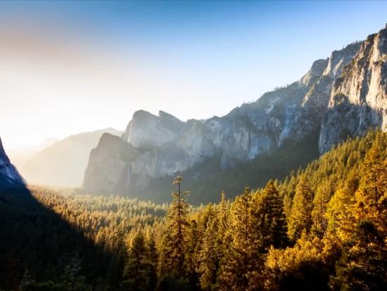 The sun peeks from behind a mountain at Yosemite