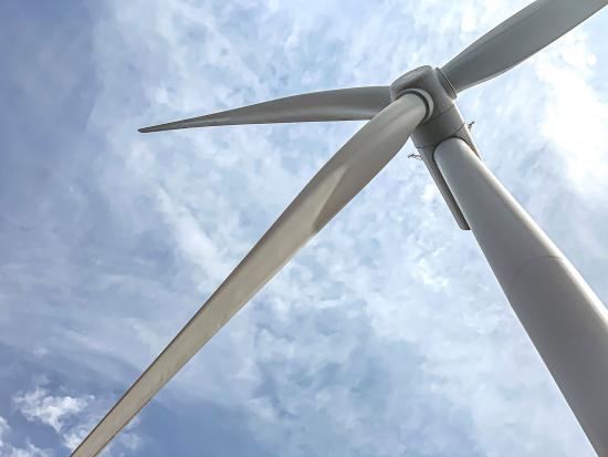 Top of wind turbine in cloudy sky