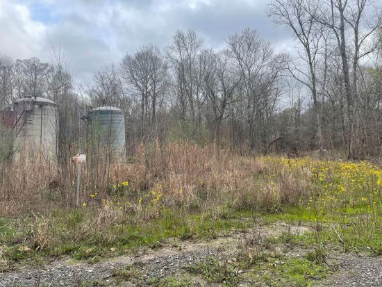 Orphaned oil and gas equipment in grassy field