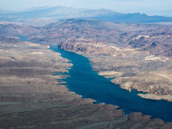 Aerial view of large river running through desert landscape. 