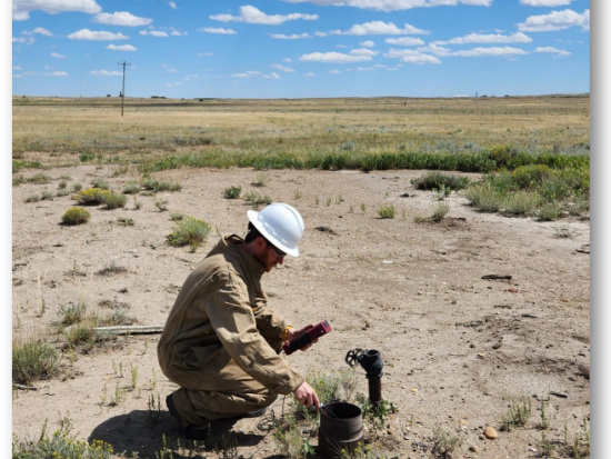 Employee measuring methane at a well site