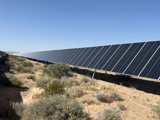 Line of solar panels in western landscape. 