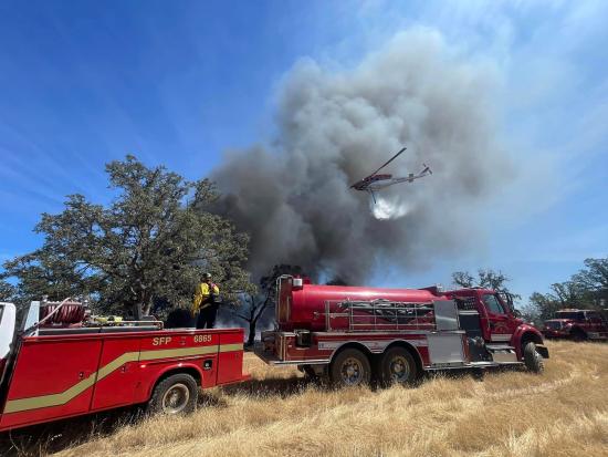 Firetruck and helicopter in grassy field