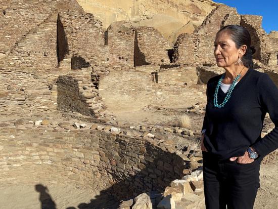 Secretary Haaland standing in front of ancient Puebloan structure. 