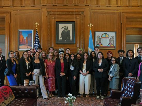 Large group of students smiling for the camera with Secretary Deb Haaland. 