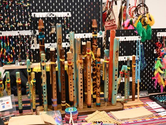 Table displaying handcrafted flutes and other artwork. 