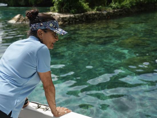 Secretary Haaland looks down at water from a boat