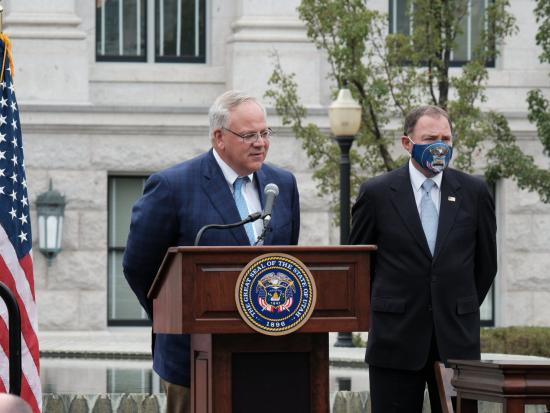 Secretary Bernhardt stands at an outdoor podium in front of a large stone building.