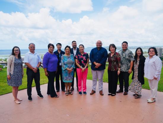 Secretary Haaland and group of people posing in front of ocean view. 