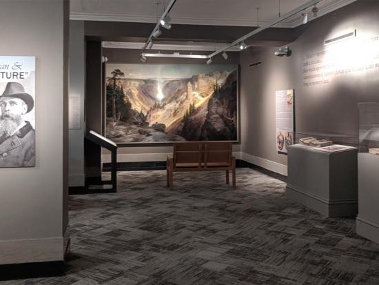 View of the "Thomas Moran & the 'Big Picture'" exhibition with panels, text, graphics, exhibition cases, and "The Grand Canyon of the Yellowstone" painting