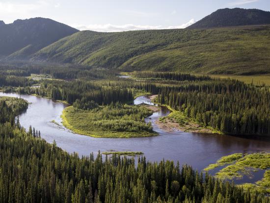 River cutting through a valley with mountains in the background.