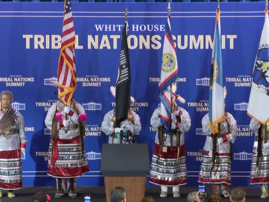 A Native American color guard displays flags on stage during the opening of the White House Tribal Nations Summit