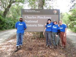 Three members of work crew at sign of Charles Pickney National Historical Site