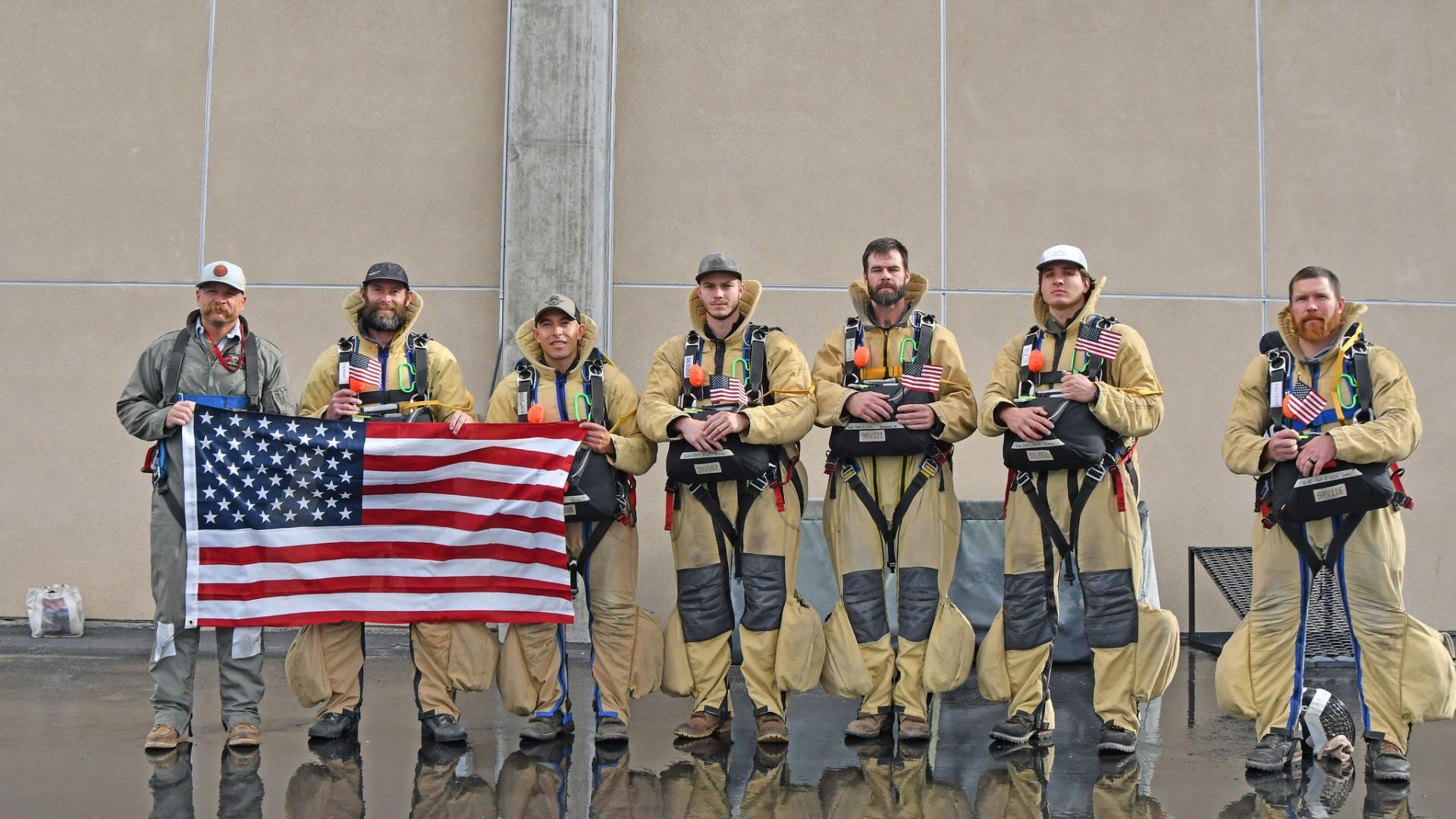 BLM smokejumpers hold a U.S. flag before departing for a Canada wildfire assignment. 