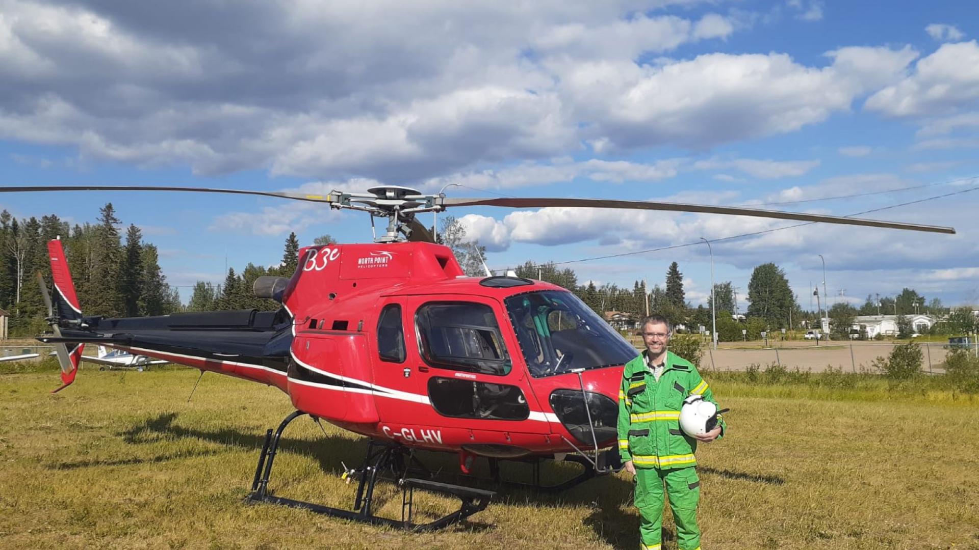 Peter Brick stands next to a helicopter before taking a helicopter flight. 