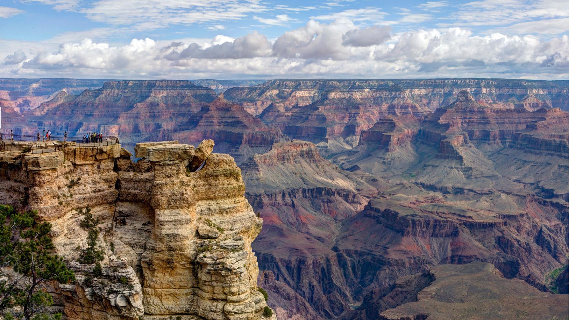 Layered rocky canyon with a blue cloudy sky. 