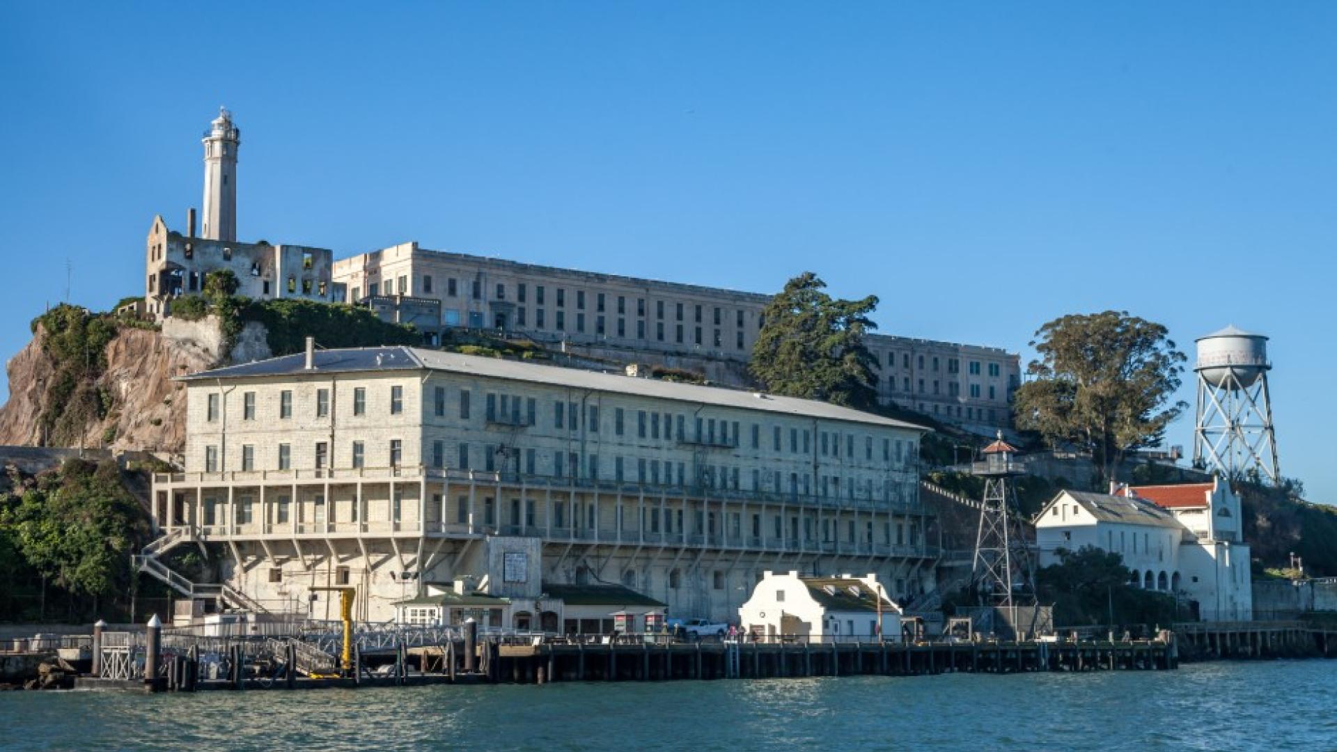 A view of the dock at Alcatraz Island with the cell house and lighthouse in the background