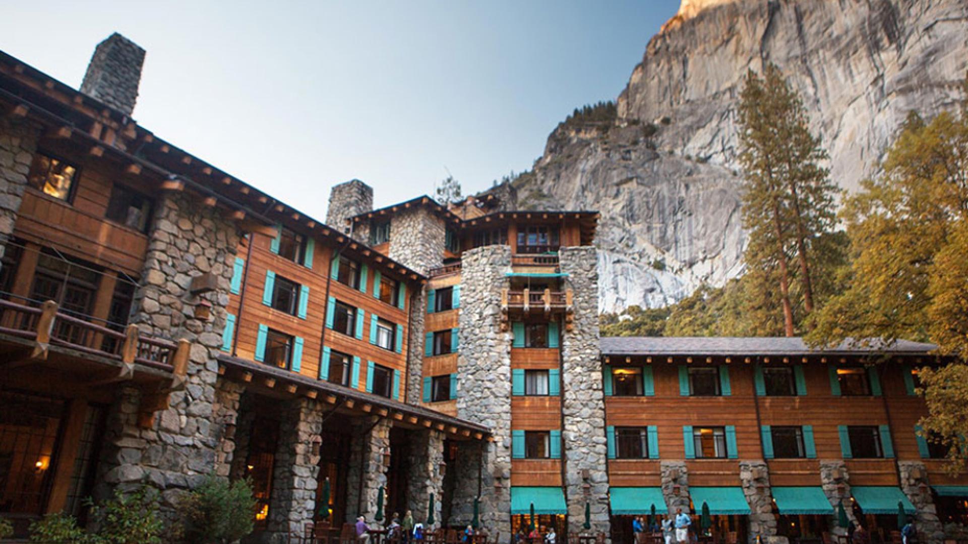 The Ahwahnee with visitors in foreground on lawn and at tables