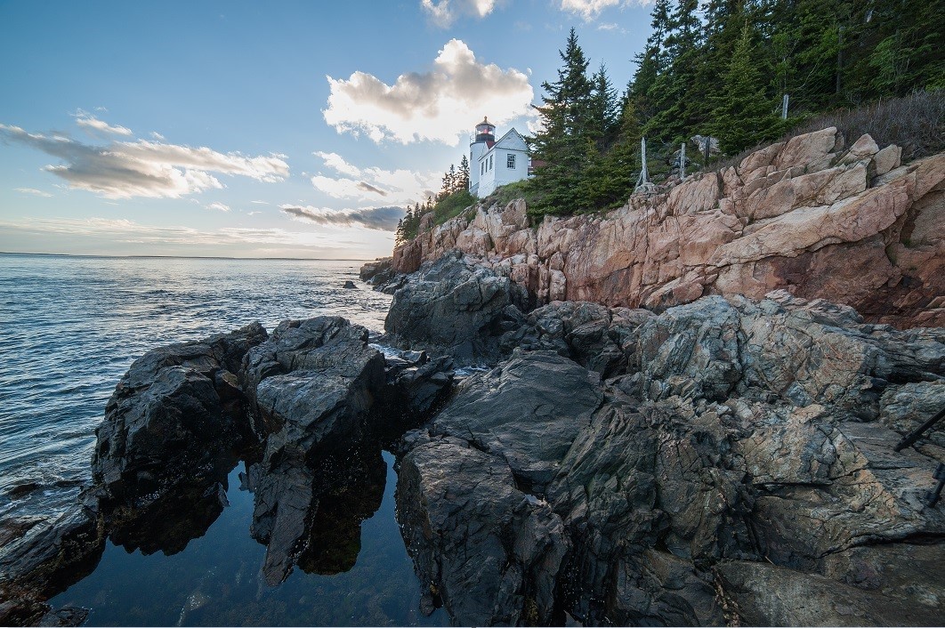 Lighthouse sits along a rugged shoreline at Bass Harbor Head Light Station.