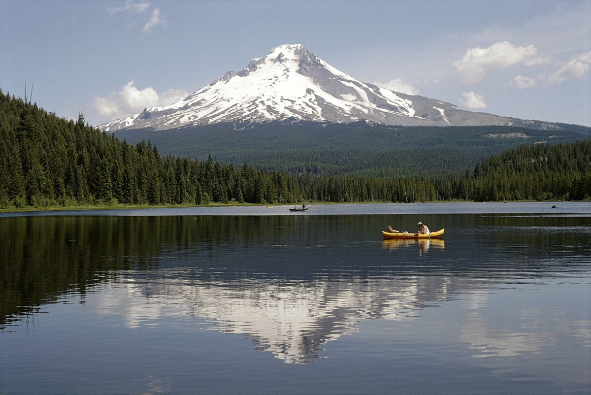 A canoer glides along the mirror image of Mt. Hood reflected in the still waters of Trillium Lake.