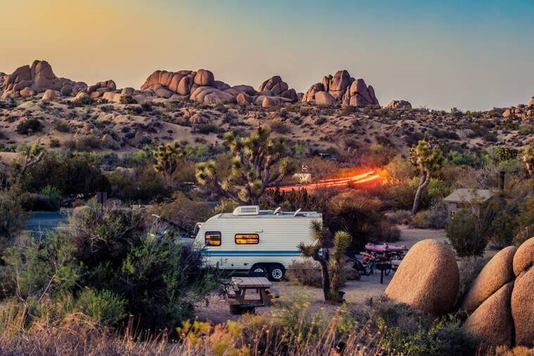 White and green camper in a desert landscape