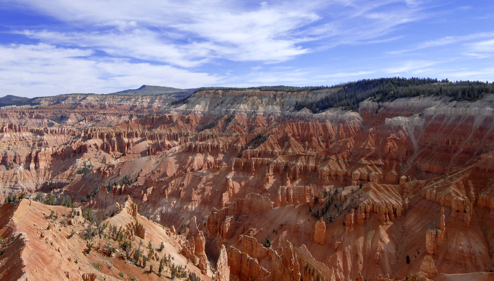 Orange and red rock formations form giant walls of a canyon.