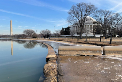 The Tidal Basin shows disrepair in the seawalls with water rising past the walls. Jefferson Memorial and Washington Monument are visible in the background. 