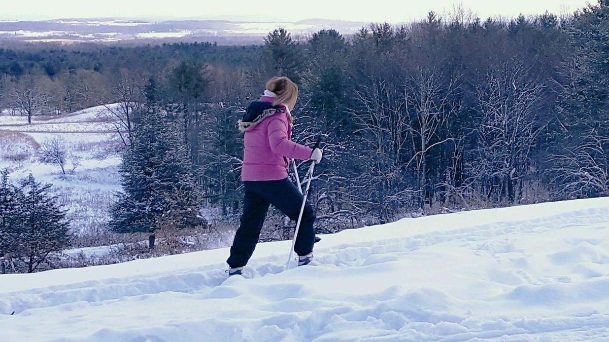 Skiier treks along snowy trail at Saratoga National Historical Park.