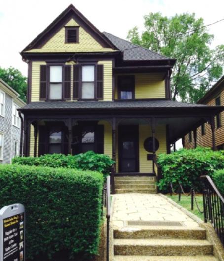 Photo by National Park Service. Martin Luther King, Jr.'s birth home is a two story wooden house with a side porch .