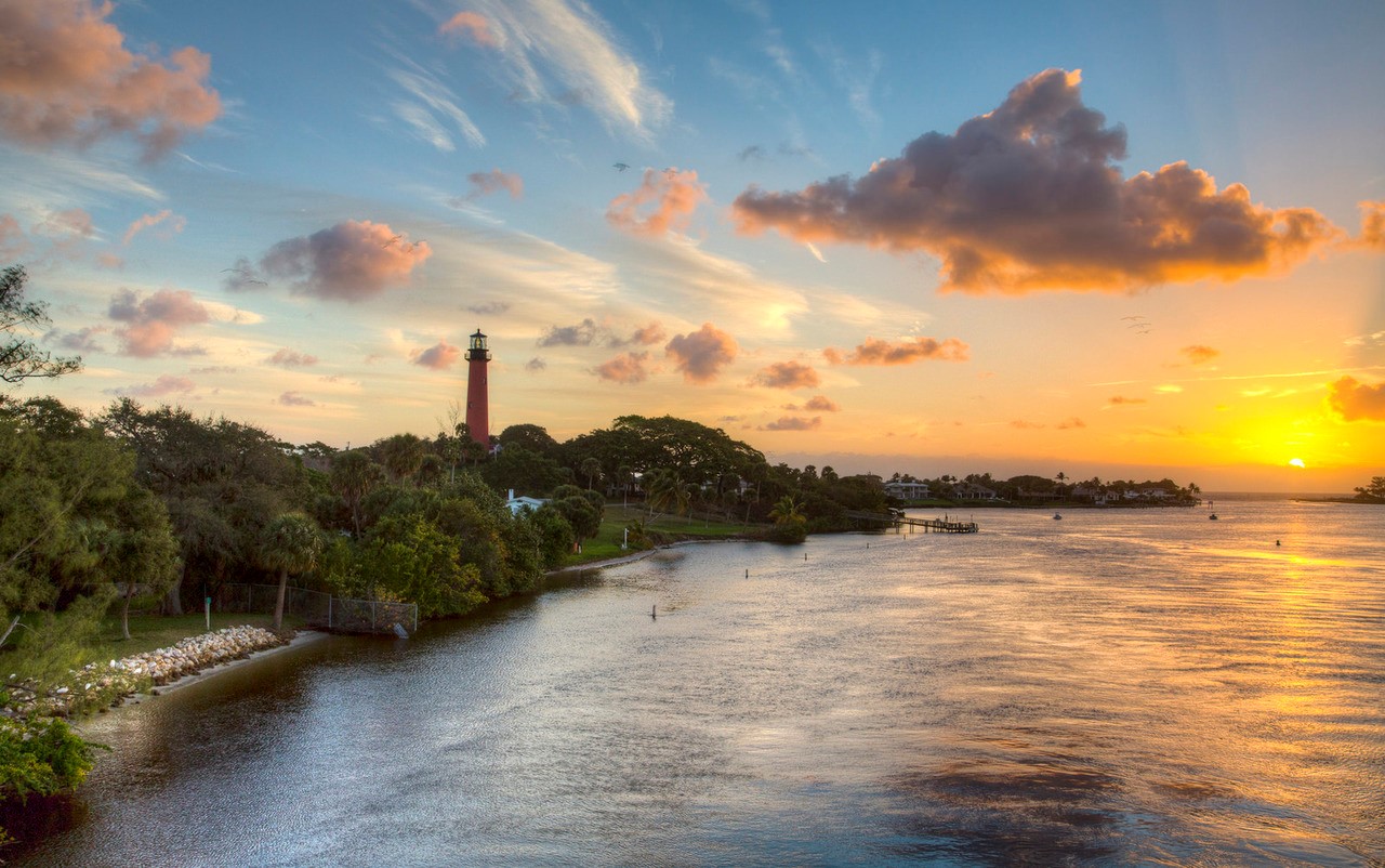 Vibrant sunset over the water and Jupiter Inlet Lighthouse.