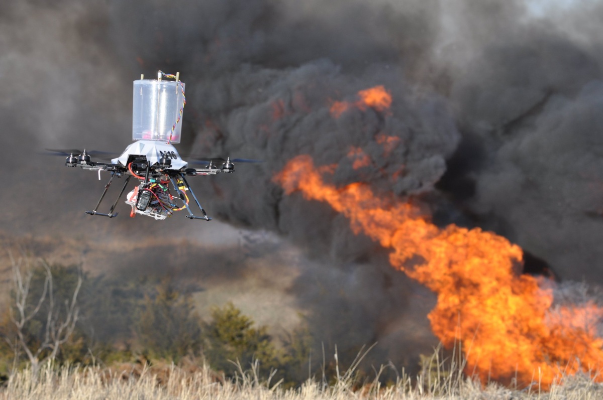 A drone flied as a fire rages in the background. 