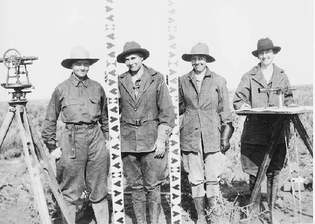 A black and white photo of four women standing with their mapping gear. 