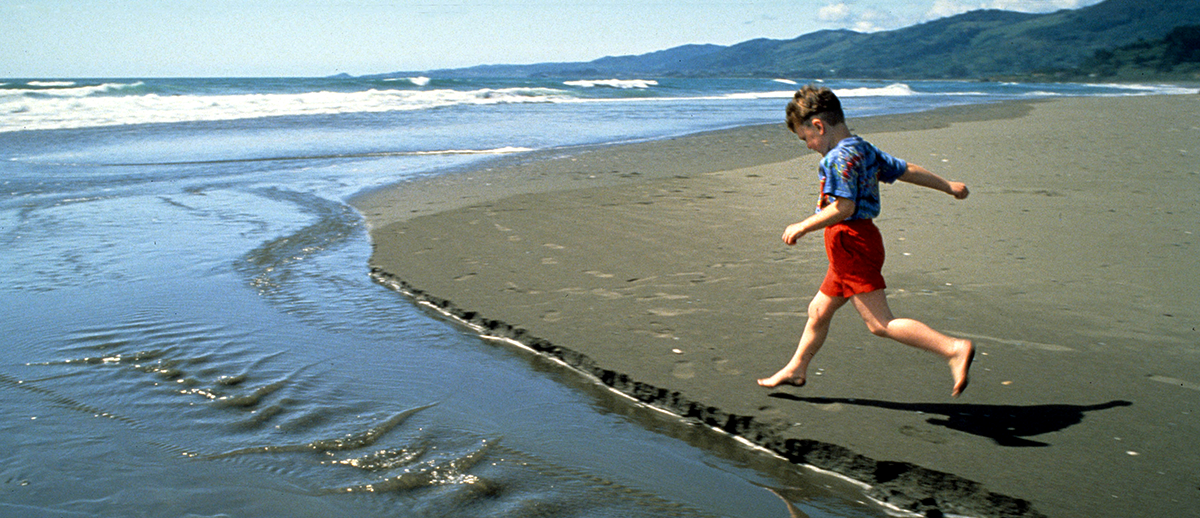 Boy running on Pacific beach